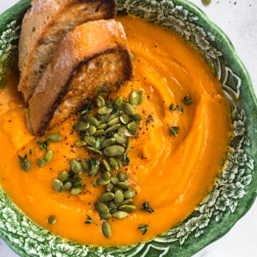 Roasted butternut squash, tomato, and garlic soup with sourdough, thyme, and pumpkin seeds
